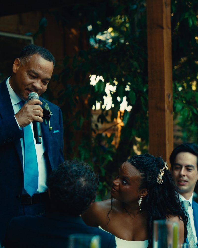 A father giving a toast at a wedding dinner outside Tuolumne Hall at Evergreen Lodge