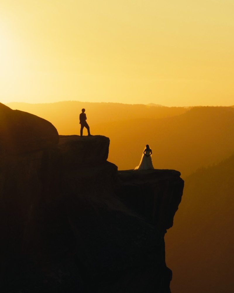 Couple silhouetted on the edge of Taft Point at sunset