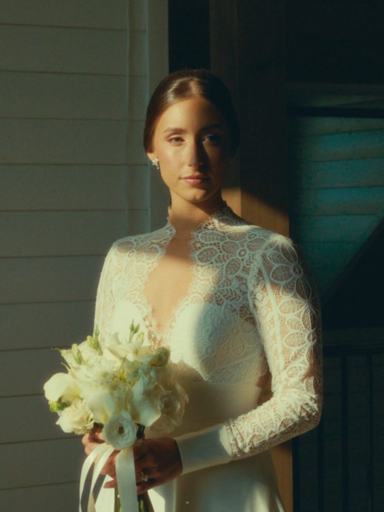 Bride holding her bouquet in a slice of window light