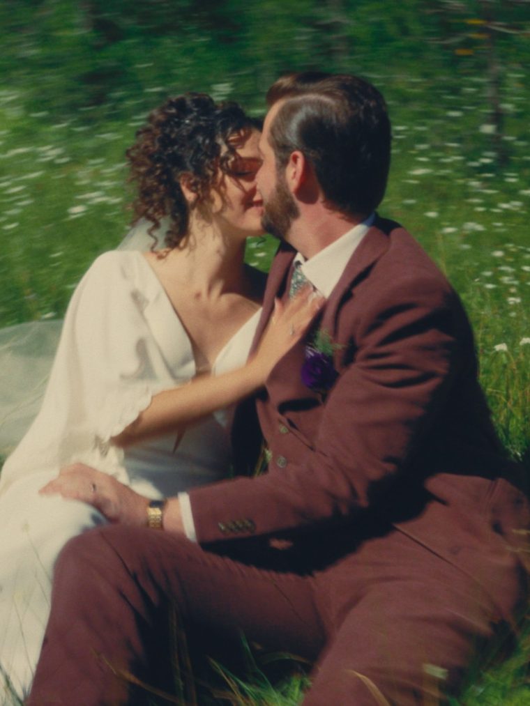 Nash and Caroline kissing in a wildflower meadow